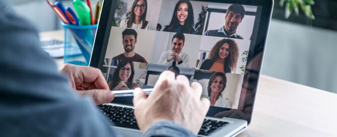 Employee speaking on video call with colleagues on online briefing with laptop at home.