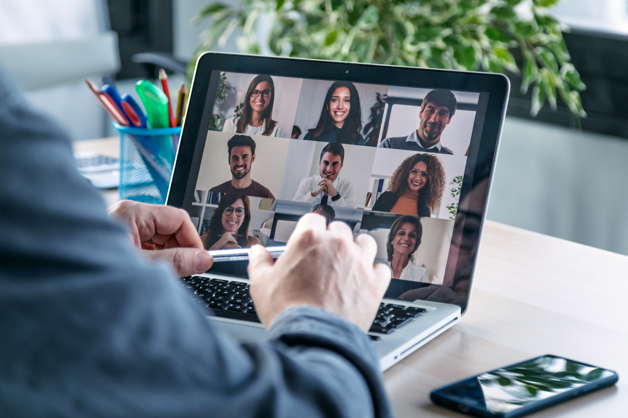 Employee speaking on video call with colleagues on online briefing with laptop at home.